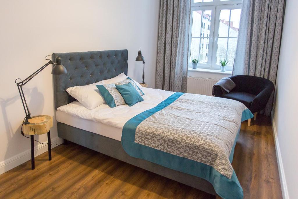 - une chambre avec un lit et une chaise dans l'établissement Starotoruński apartament, à Toruń