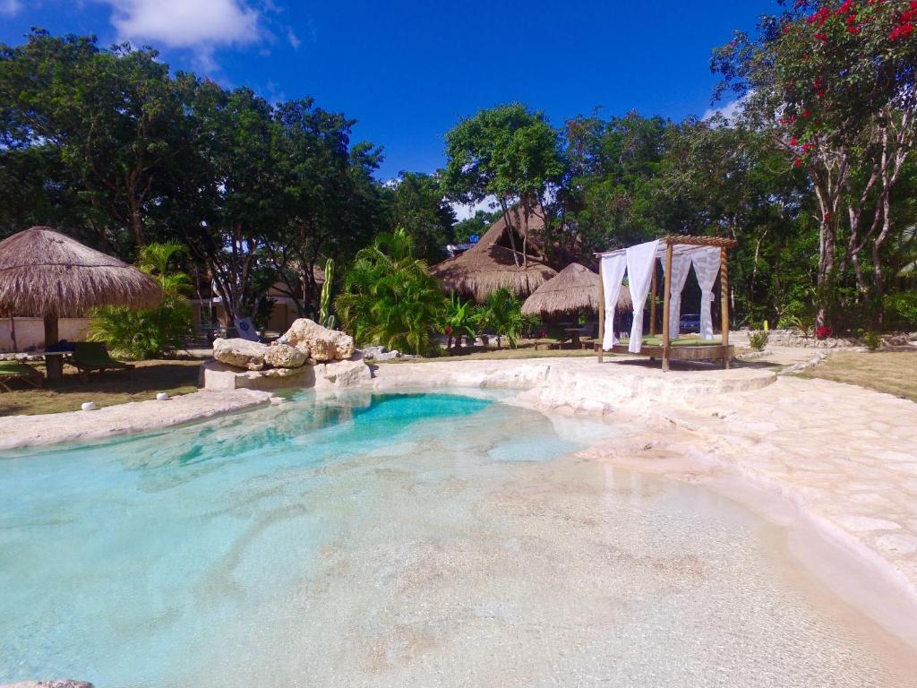 
a beach with a swimming pool and a beach chair at Villa Morena Boutique Hotel Ecoliving in Akumal

