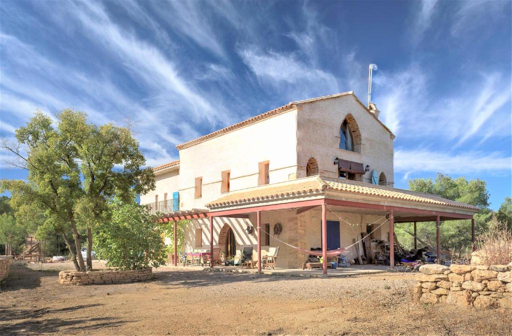 a building in the middle of a dirt field at Granja Masia Katmandu in Cretas