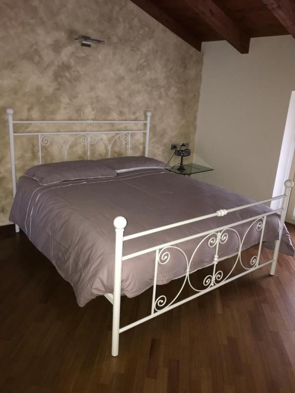 B&B Lodi Centro في لودي: سرير أبيض في غرفة نوم مع أرضية خشبية
