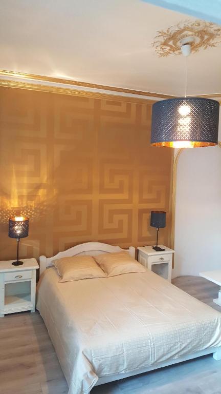 una camera da letto con un letto con due comodini e due lampade di Luxury Suite lilas 3 a Digione