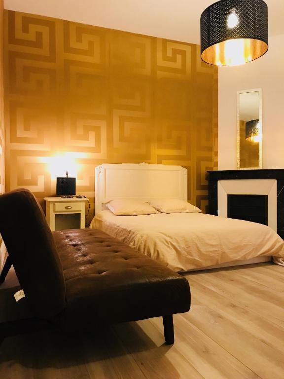 une chambre avec un lit et un banc dans l'établissement Luxury Suite Lilas 2, à Dijon