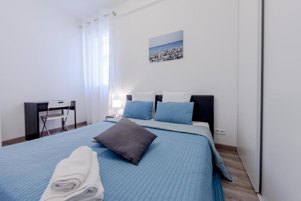 une chambre avec un grand lit avec des draps bleus dans l'établissement Apartment Nice Center Barralis, à Nice
