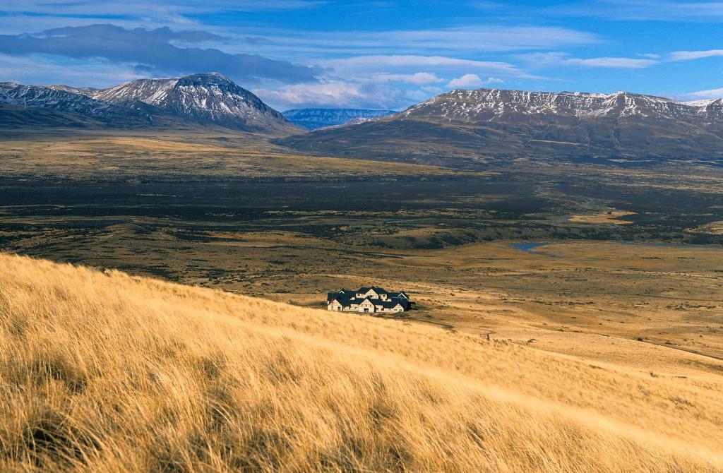 a house in the middle of a field with mountains at EOLO Patagonia Spirit - Relais & Chateaux in El Calafate
