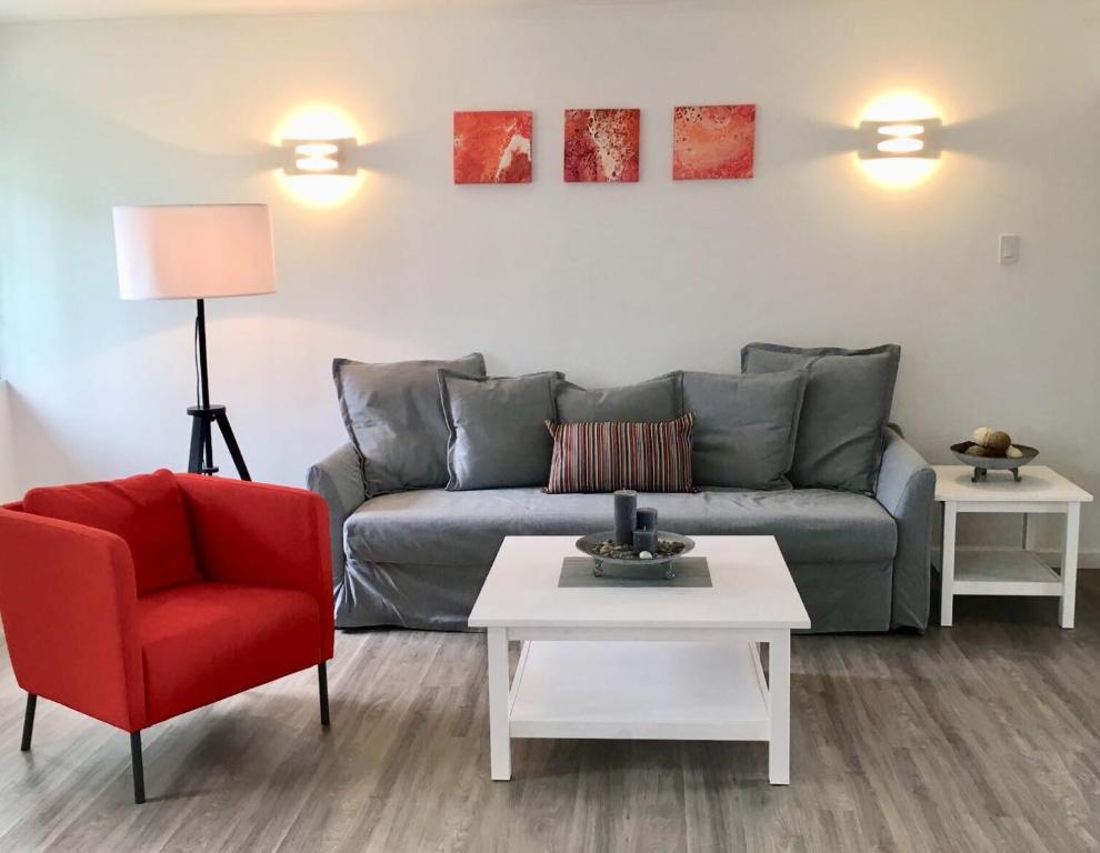 un soggiorno con divano e sedia rossa di Dover Woods Apartments a Christ Church