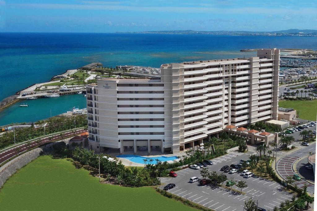 une vue aérienne sur un grand bâtiment à côté de l'eau dans l'établissement Moon Ocean Ginowan Hotel & Residence, à Ginowan