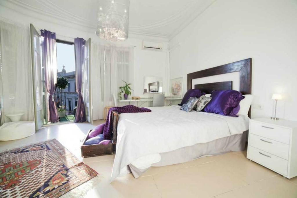 バルセロナにあるBALCONIES AND VIEWS in City centerの白いベッドルーム(紫色の枕を使用した大型ベッド1台付)