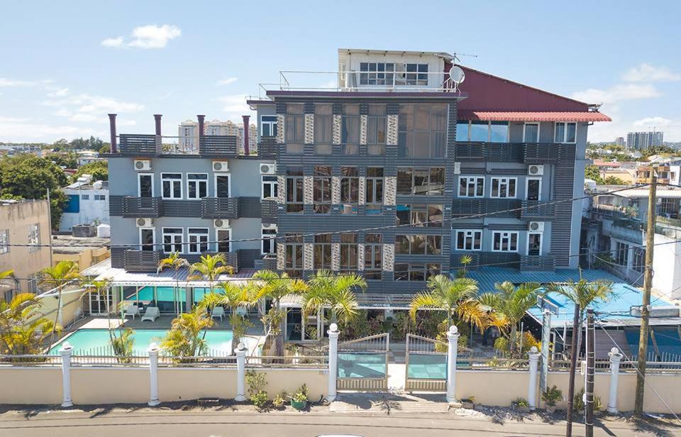 um grande edifício com uma piscina em frente em Mountview Tourist Residence em Quatre Bornes