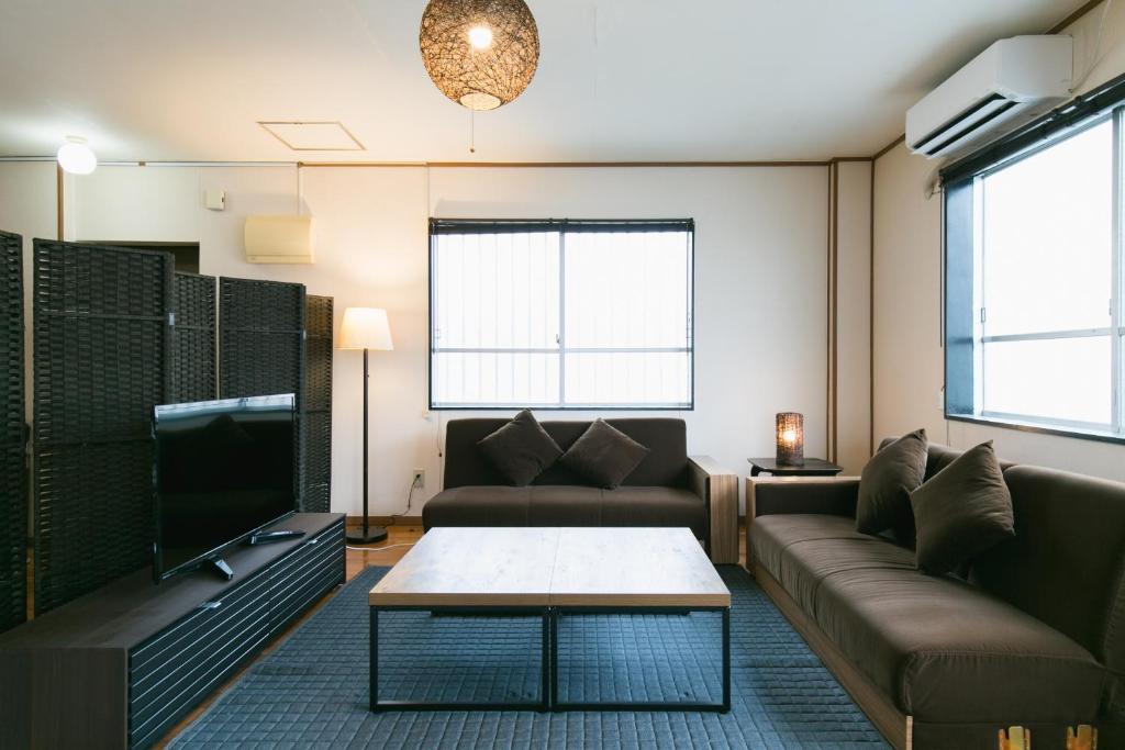 Okinawa Naha Nishi في ناها: غرفة معيشة مع أريكة وطاولة