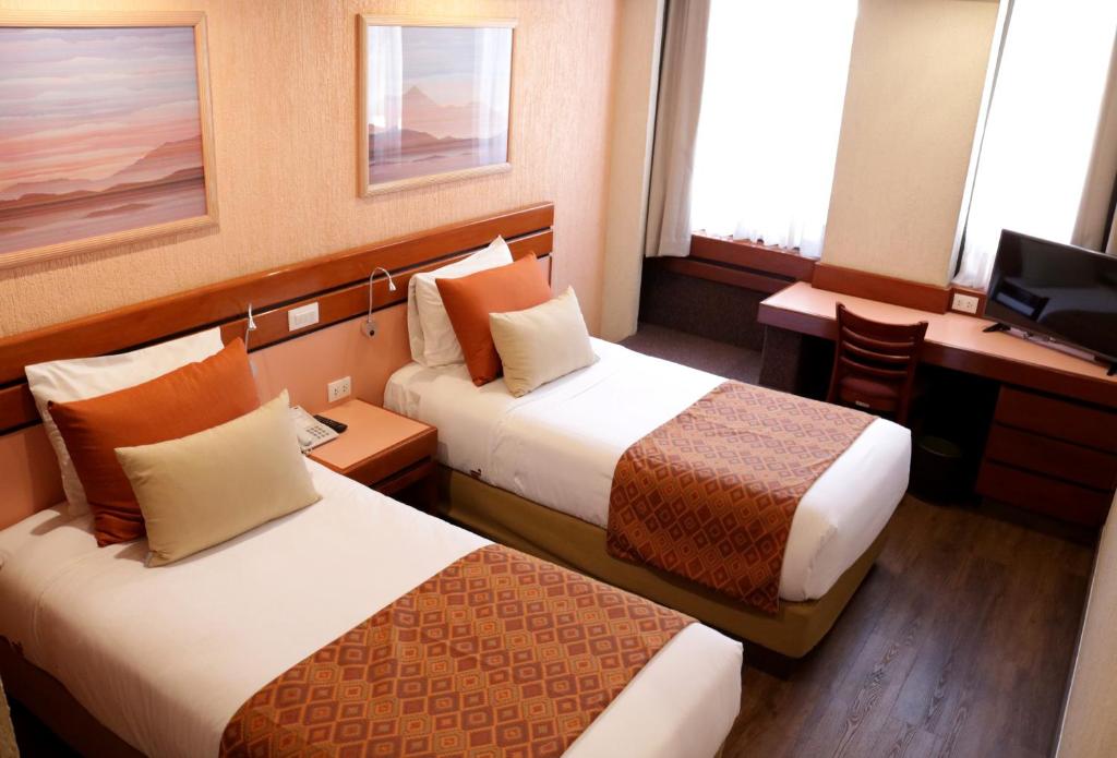 Cette chambre comprend deux lits et un bureau. dans l'établissement Hotel Marlowe Centro Histórico, à Mexico