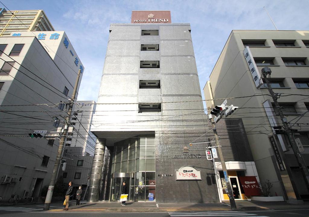 Un palazzo alto con un cartello sopra. di Hotel Trend Funabashi a Funabashi