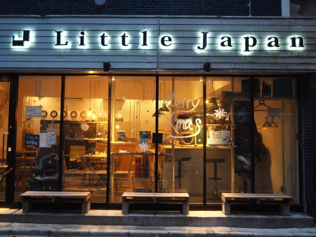 a store front with benches in front of a store at Little Japan in Tokyo