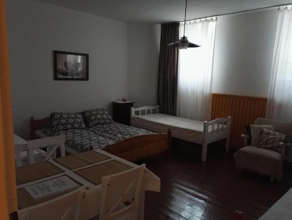 ミシュコルツにあるNépkerti Vendégházのベッド1台とソファが備わる小さな客室です。