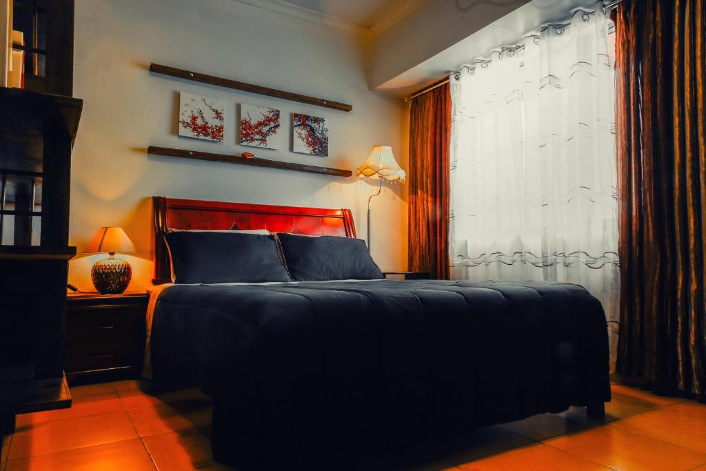 sypialnia z dużym łóżkiem i oknem w obiekcie 1015 West Insula Suites by AYS w mieście Manila