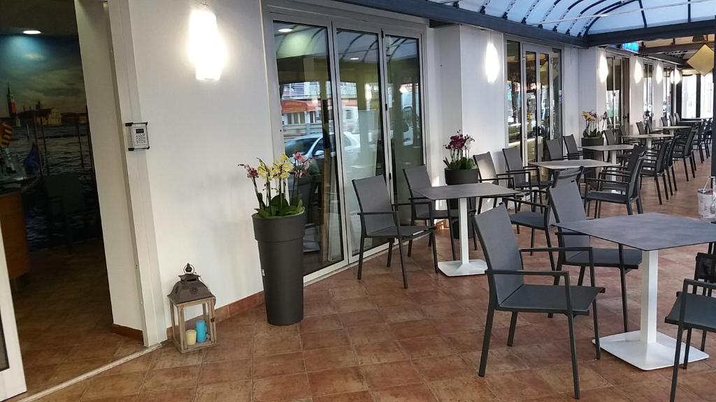 a row of tables and chairs in a restaurant at Hotel Venezia in Caorle