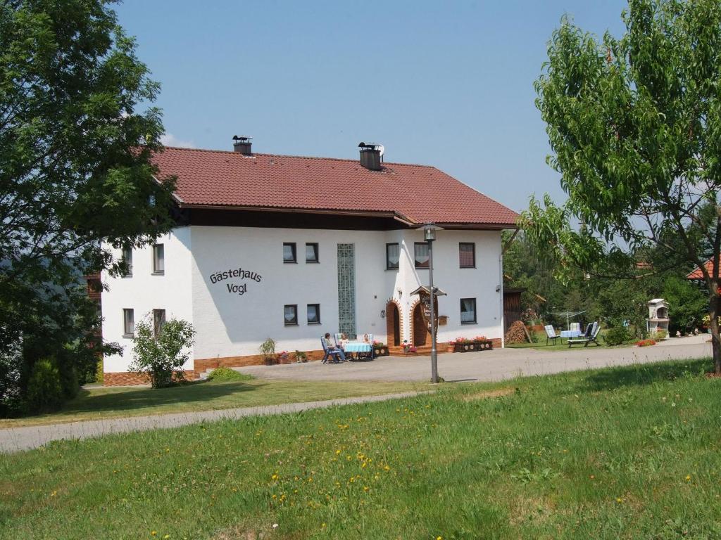 ein großes weißes Gebäude mit rotem Dach in der Unterkunft Gästehaus Vogl in Bodenmais
