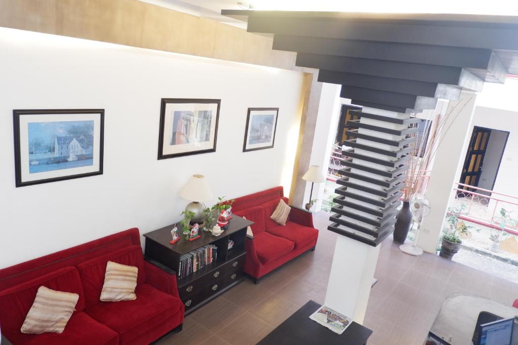長灘島的住宿－長灘島酒店，一间带红色沙发的客厅和楼梯