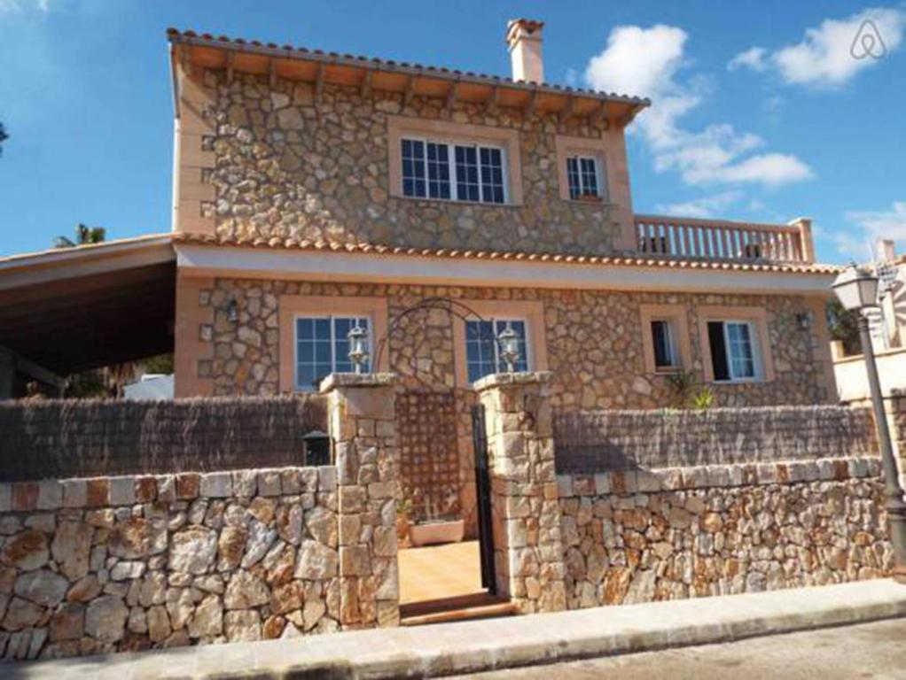 una gran casa de piedra con una pared de piedra en Can Vich, en Santanyí