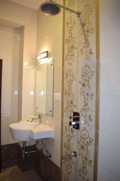 un bagno con lavandino e doccia con specchio di Suraj Haveli a Jodhpur