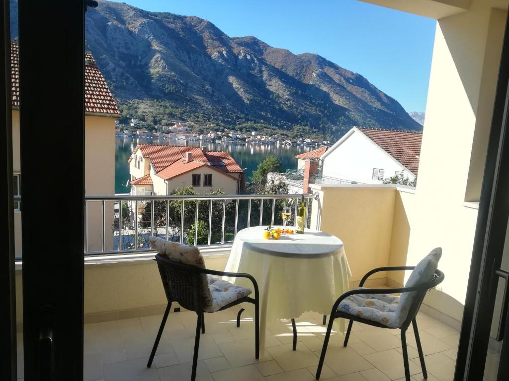 a balcony with a table and chairs and a mountain at Apartments Castello in Kotor