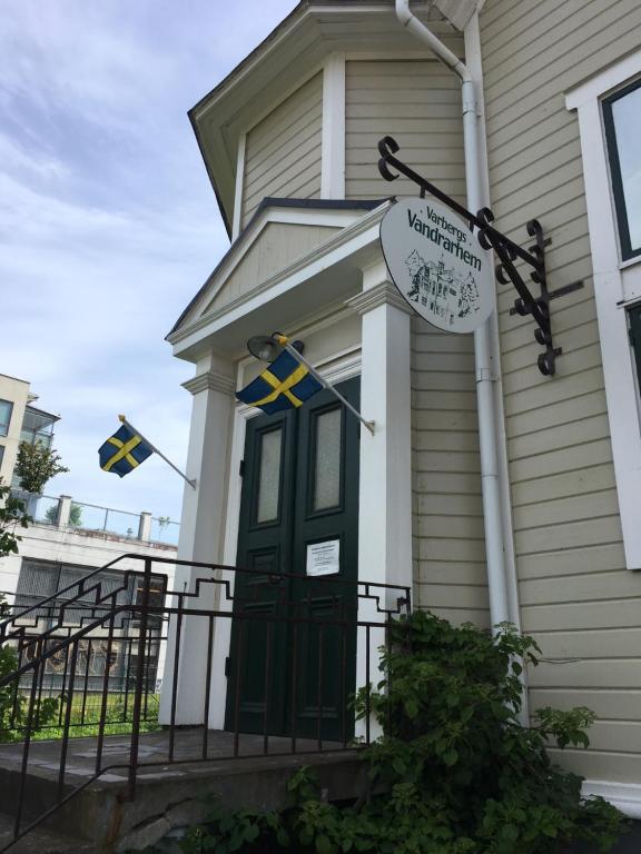 una casa con una puerta verde y un cartel en ella en Varbergs Vandrarhem en Varberg
