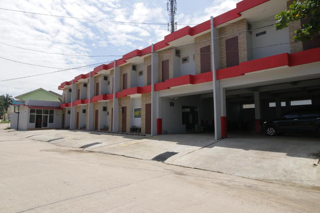 an empty parking lot in front of a building at RedDoorz near Jalan Kolonel Haji Burlian Palembang in Palembang