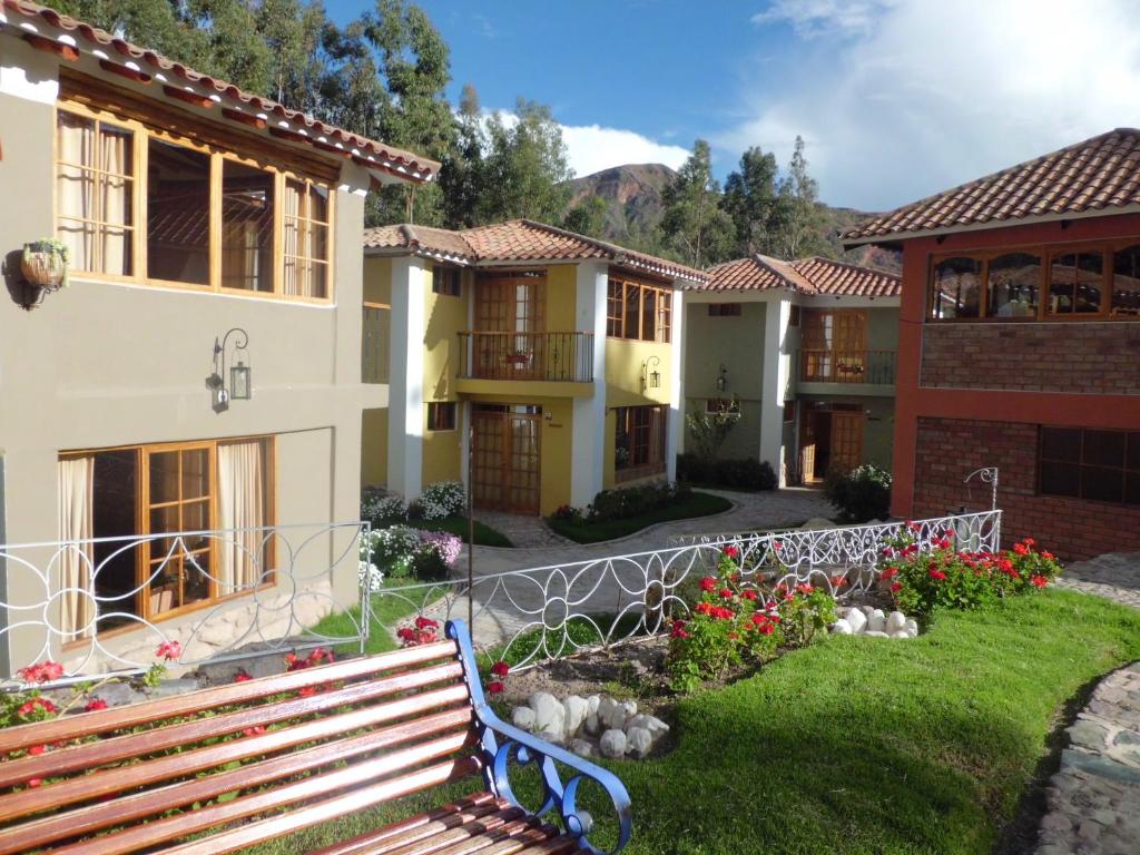a house with a bench in front of it at Hotel Pisonay Pueblo in Urubamba