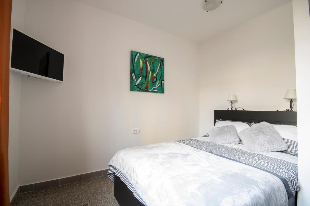 Un dormitorio con una cama y un televisor de pantalla plana. en Studio Apartmani Mini, en Rijeka