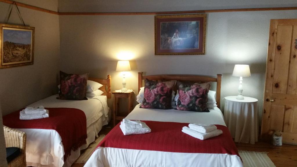 um quarto de hotel com duas camas com lençóis vermelhos em Kambro Kind em Sutherland