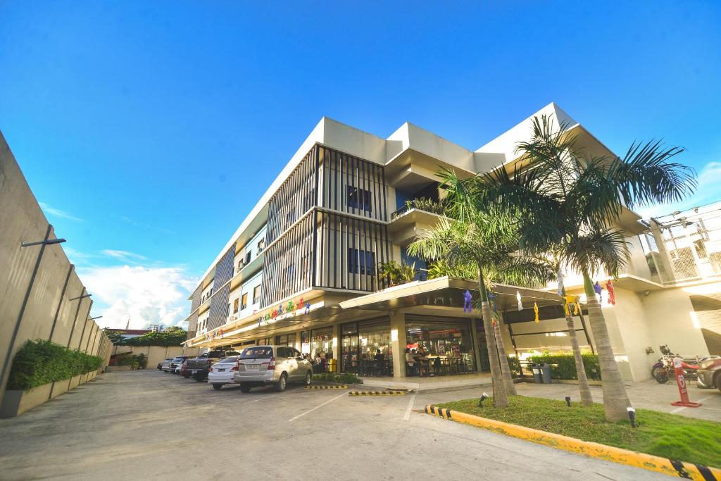 a large building with cars parked in a parking lot at Felix Residences in Cebu City