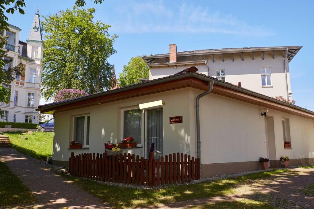 una pequeña casa blanca con una valla en Dependance Villa Graziella, en Heringsdorf