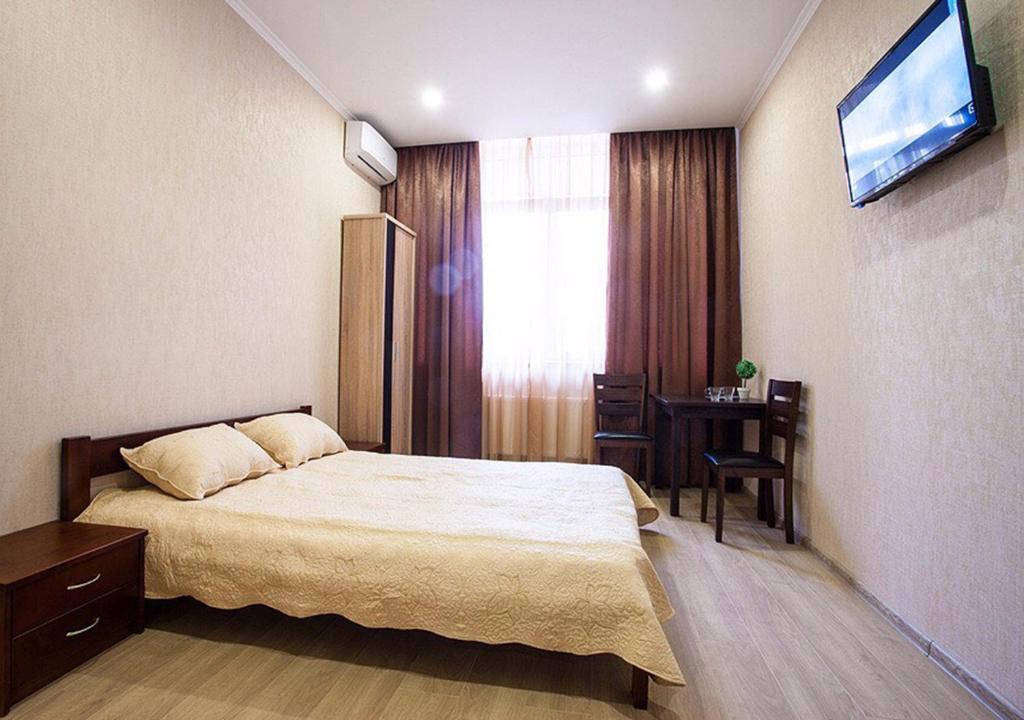 a bedroom with a bed and a table and a television at Apartment de France in Odesa