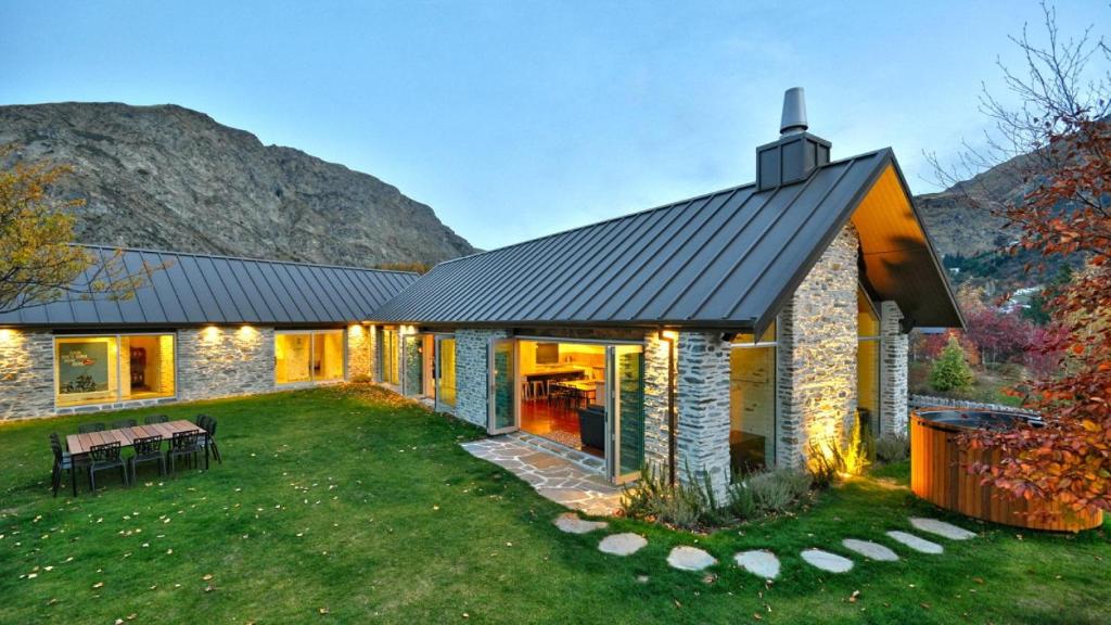 una casa de piedra con techo negro en Gucci House en Queenstown