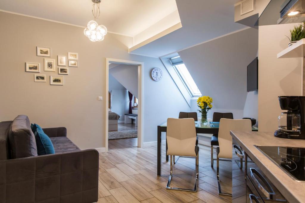 uma cozinha e sala de estar com mesa e cadeiras em udanypobyt Apartamenty Orkana Park Centrum em Zakopane