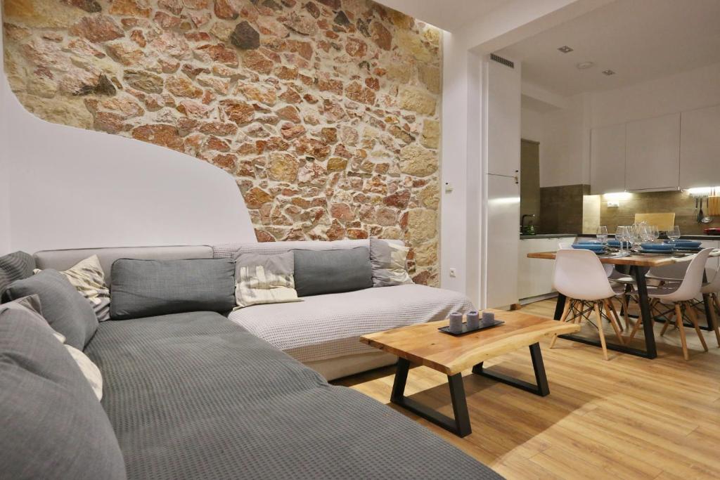 salon z kanapą i kamienną ścianą w obiekcie Luxury Apartment near Acropolis w Atenach