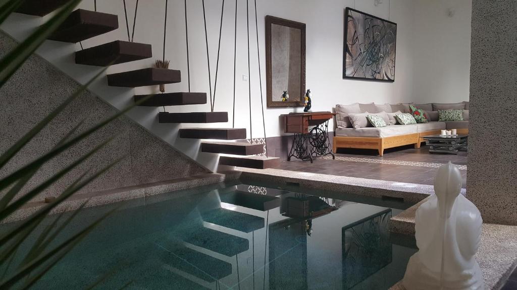 a living room with a swimming pool and a living room with a couch at Dar d'Art in Marrakesh