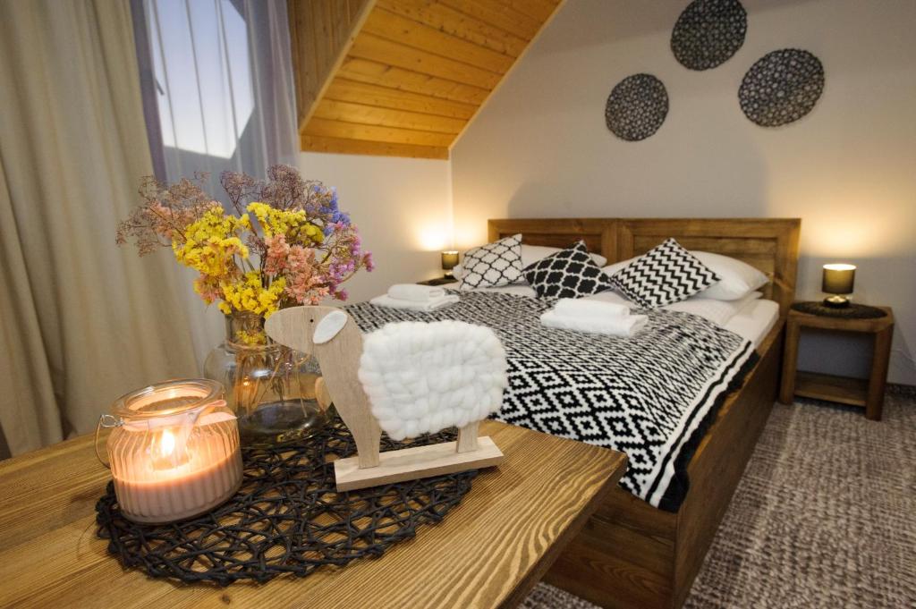 ein Schlafzimmer mit einem Bett und einem Tisch mit einer Kerze in der Unterkunft SMEREK 2 in Wetlina