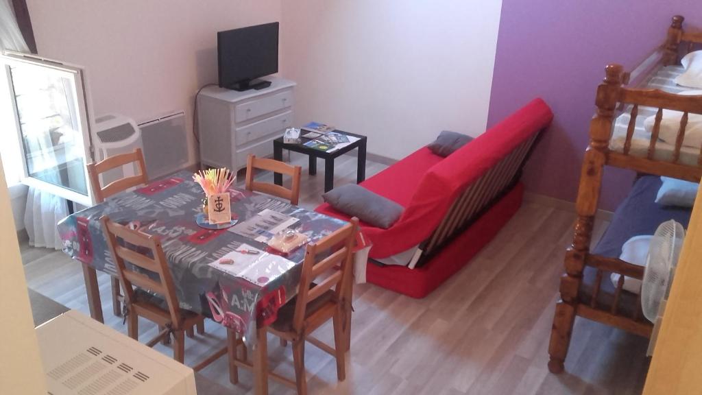 sala de estar con mesa, cama y sofá en L'oiseau bleu, en Salin-de-Giraud