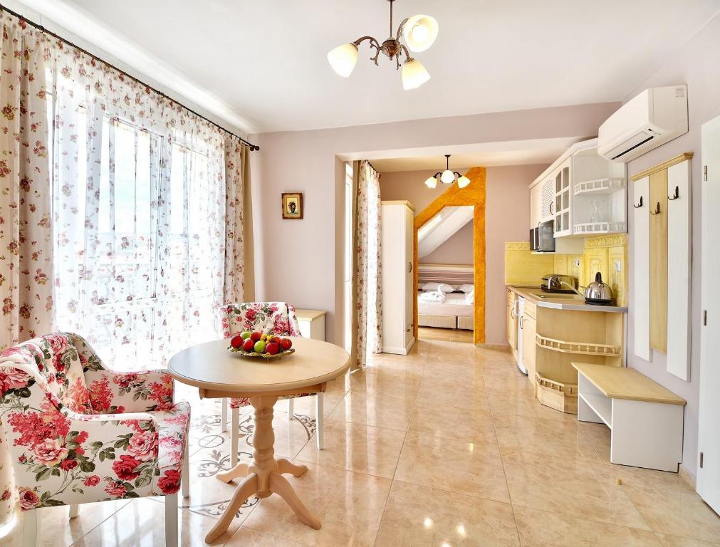 a living room with a table and chairs and a kitchen at Sirena Palace Family Hotel in Obzor