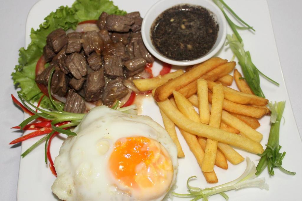 a plate of food with an egg and french fries at Siem Reap Pub Hostel in Siem Reap