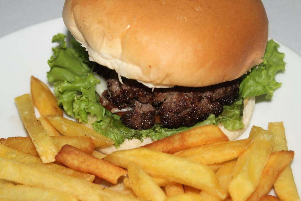 a hamburger and french fries on a white plate at Siem Reap Pub Hostel in Siem Reap