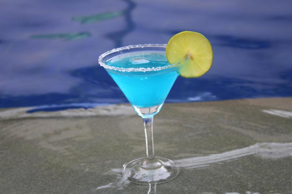 a blue drink in a glass with a lime at Siem Reap Pub Hostel in Siem Reap
