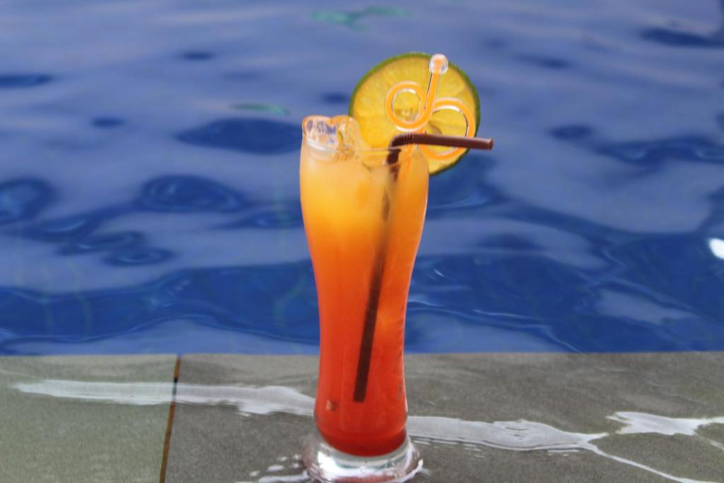 a drink sitting on a table next to a pool at Siem Reap Pub Hostel in Siem Reap