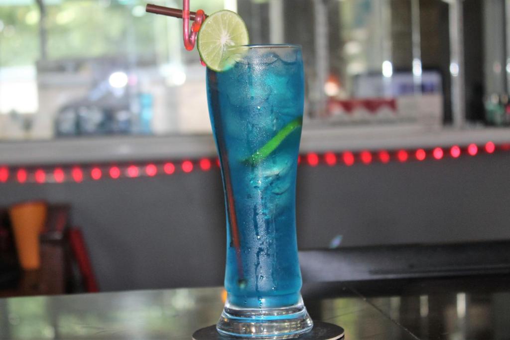 a blue drink with a lime on a table at Siem Reap Pub Hostel in Siem Reap