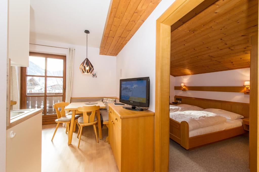 a bedroom with a bed and a table with a television at Haus Fercher in Grossarl