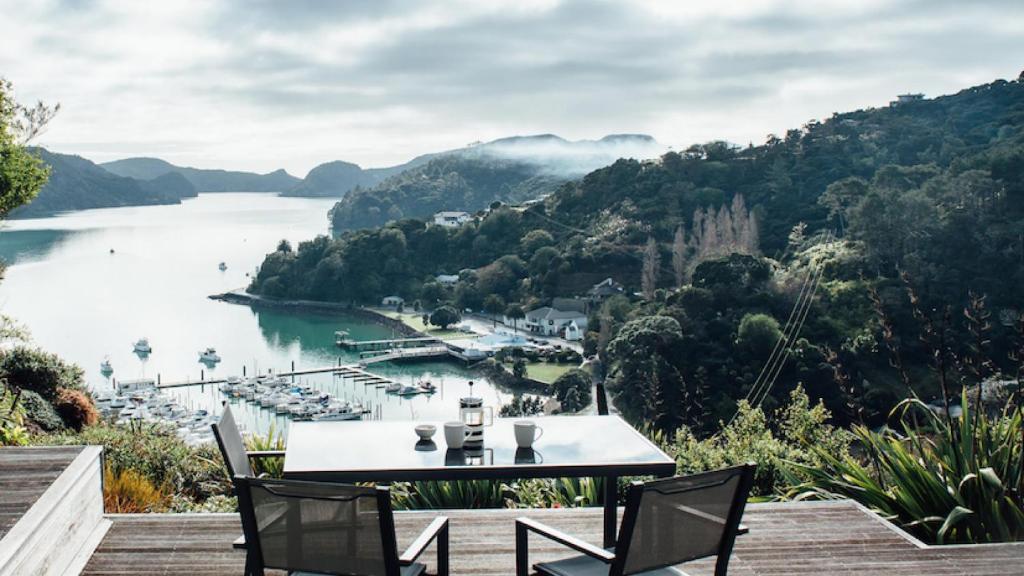 a table and chairs on a deck overlooking a body of water at Wonderful Whangaroa in Whangaroa