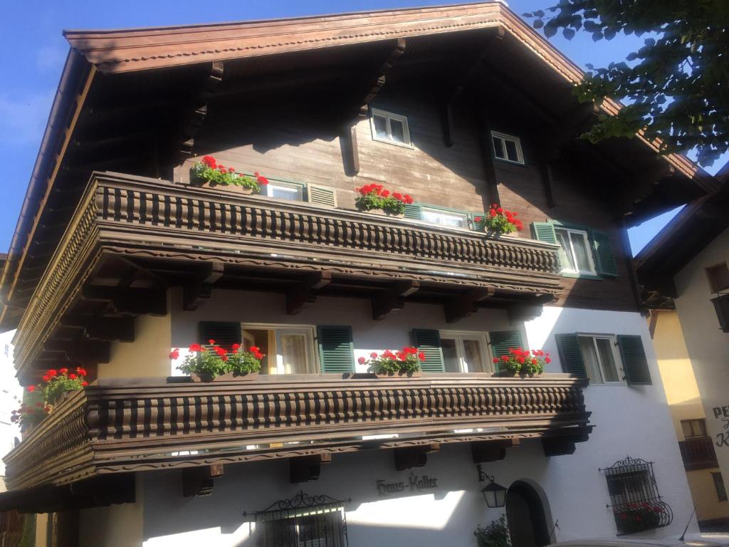 a building with a balcony with flowers on it at Koller, Pension Haus in Kitzbühel