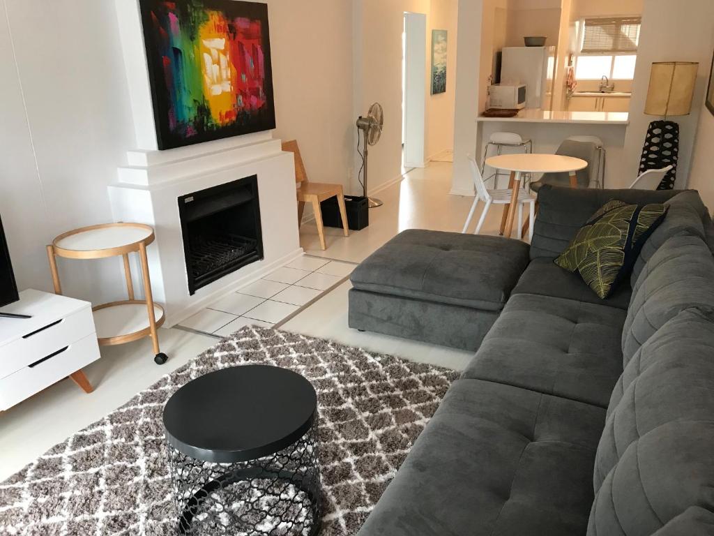 a living room with a couch and a fireplace at De Waterkant Piazza Apartments in Cape Town