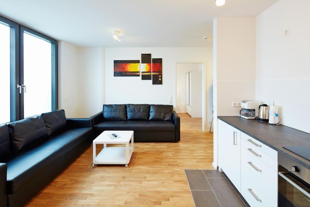 a living room with a black couch and a table at City Apartment Stuttgart in Stuttgart