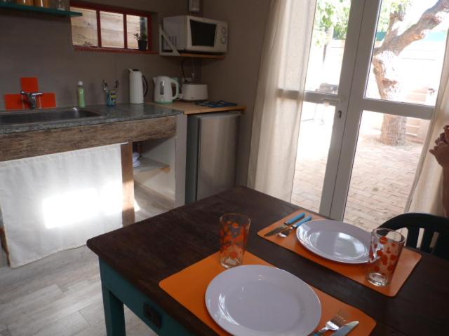una cocina con una mesa con dos platos. en El Tamarisco en Puerto Pirámides